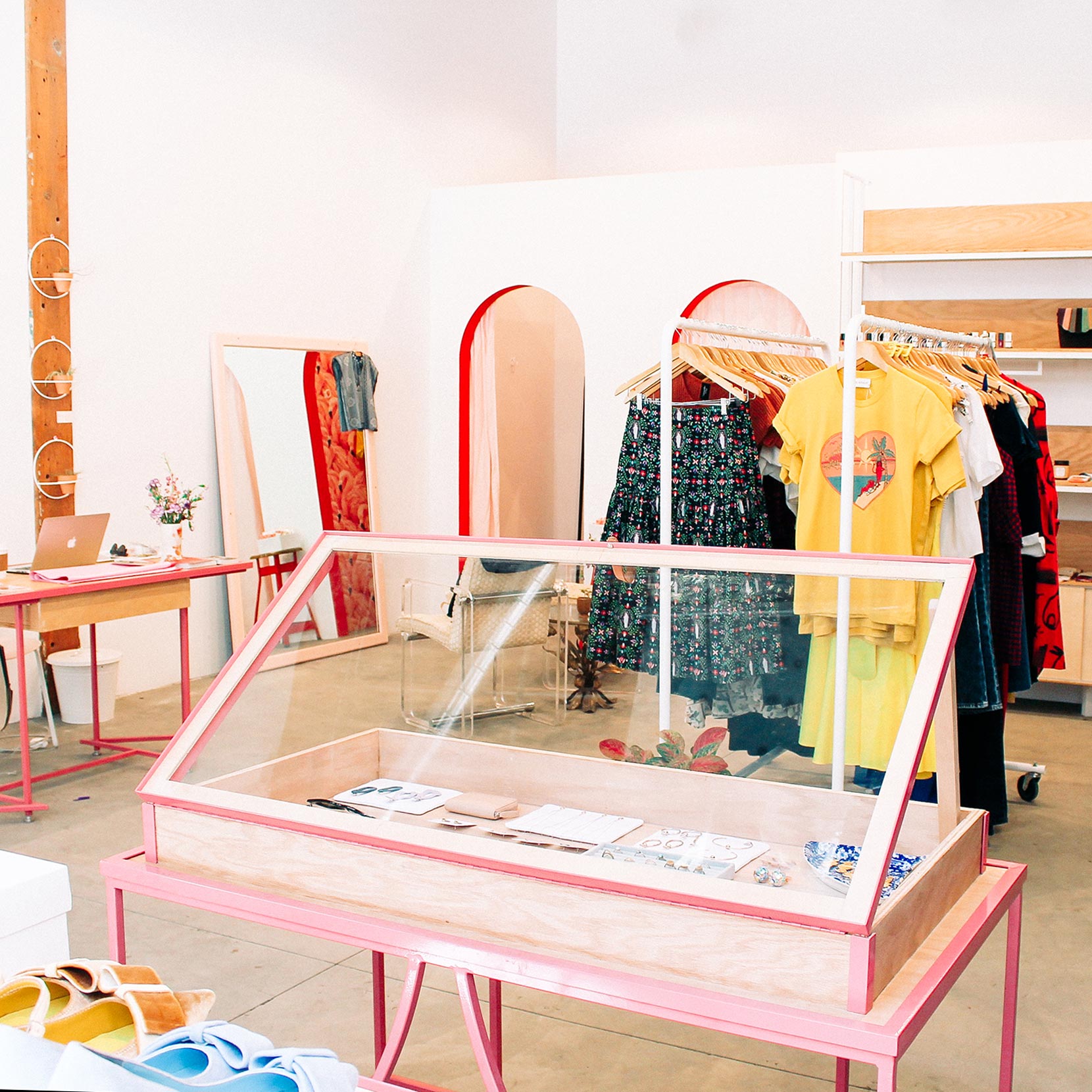 interior of a store with pink shelf and clothes