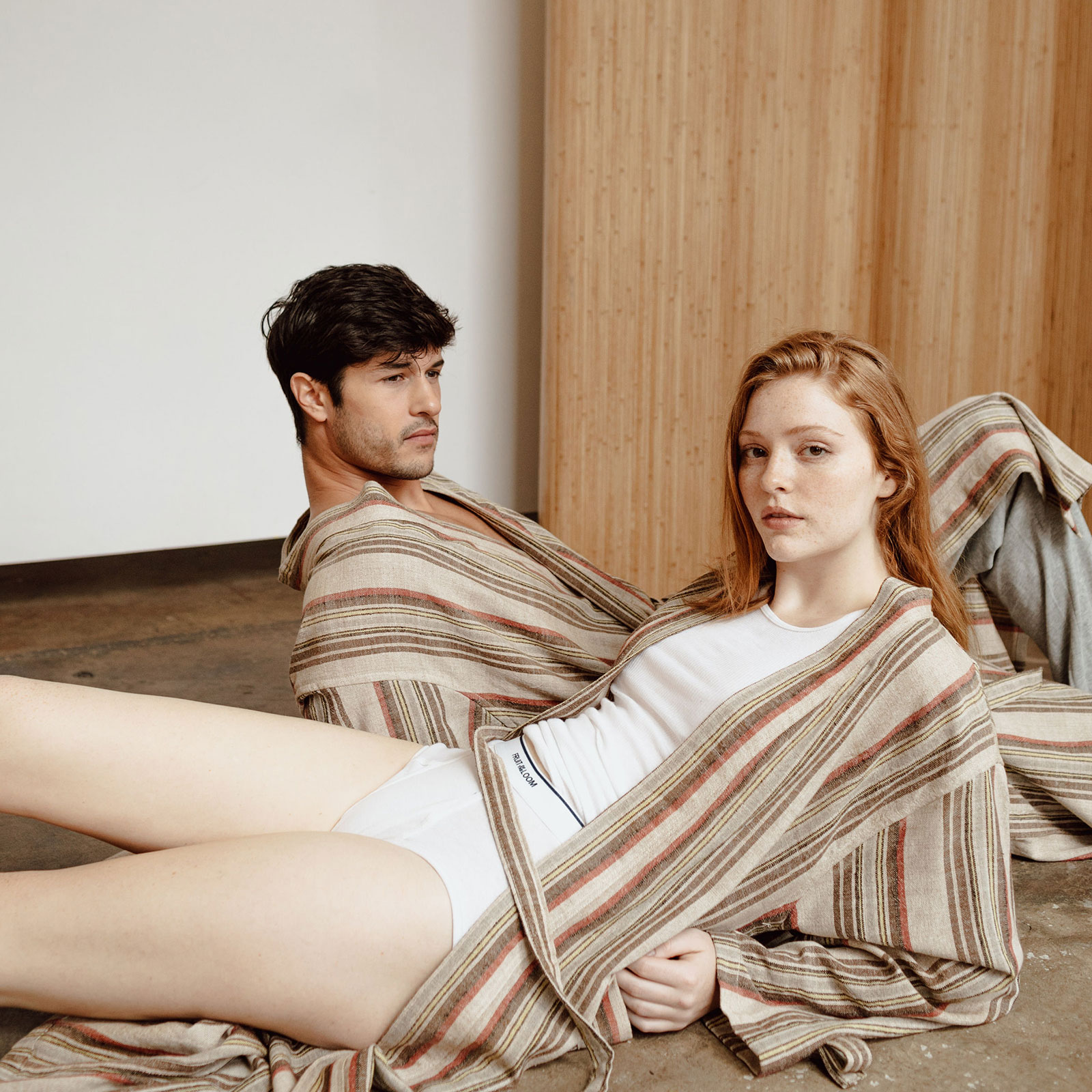 man and woman lying in opposite directions wearing beige kimono robe and white under garments