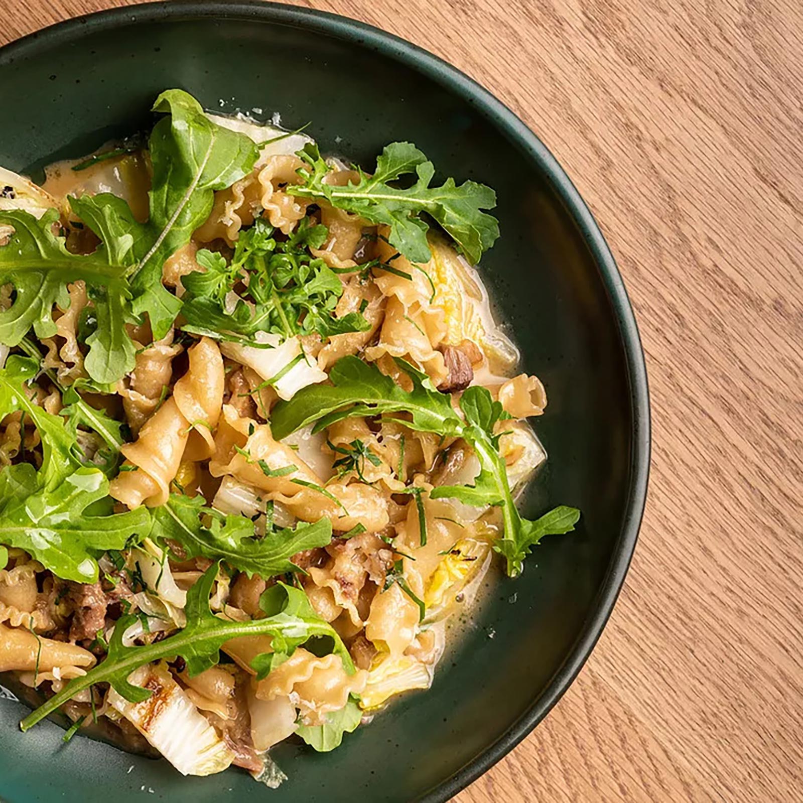 birds eye view of plate of pasta and arugula food dish