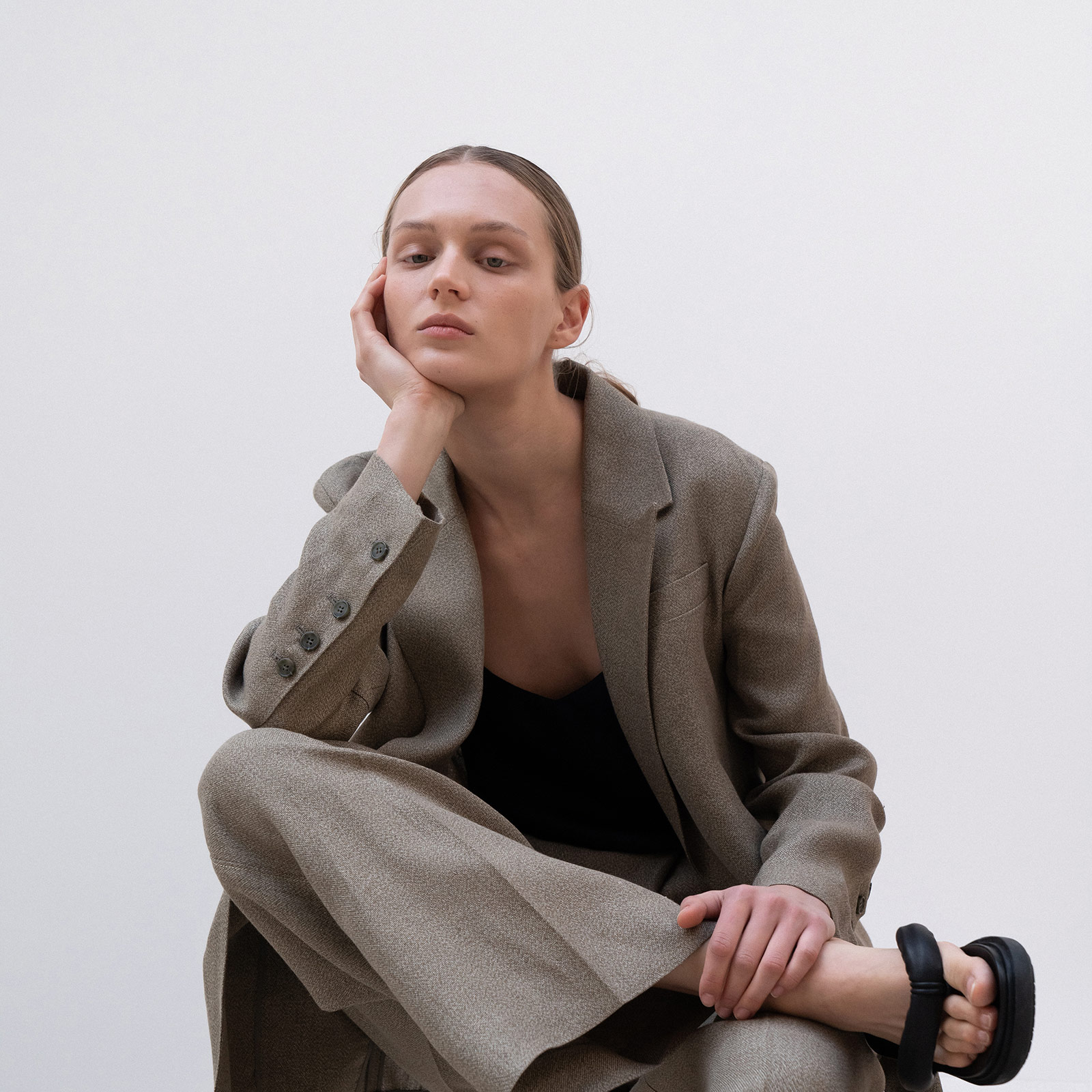 woman wearing suit and resting head in hand