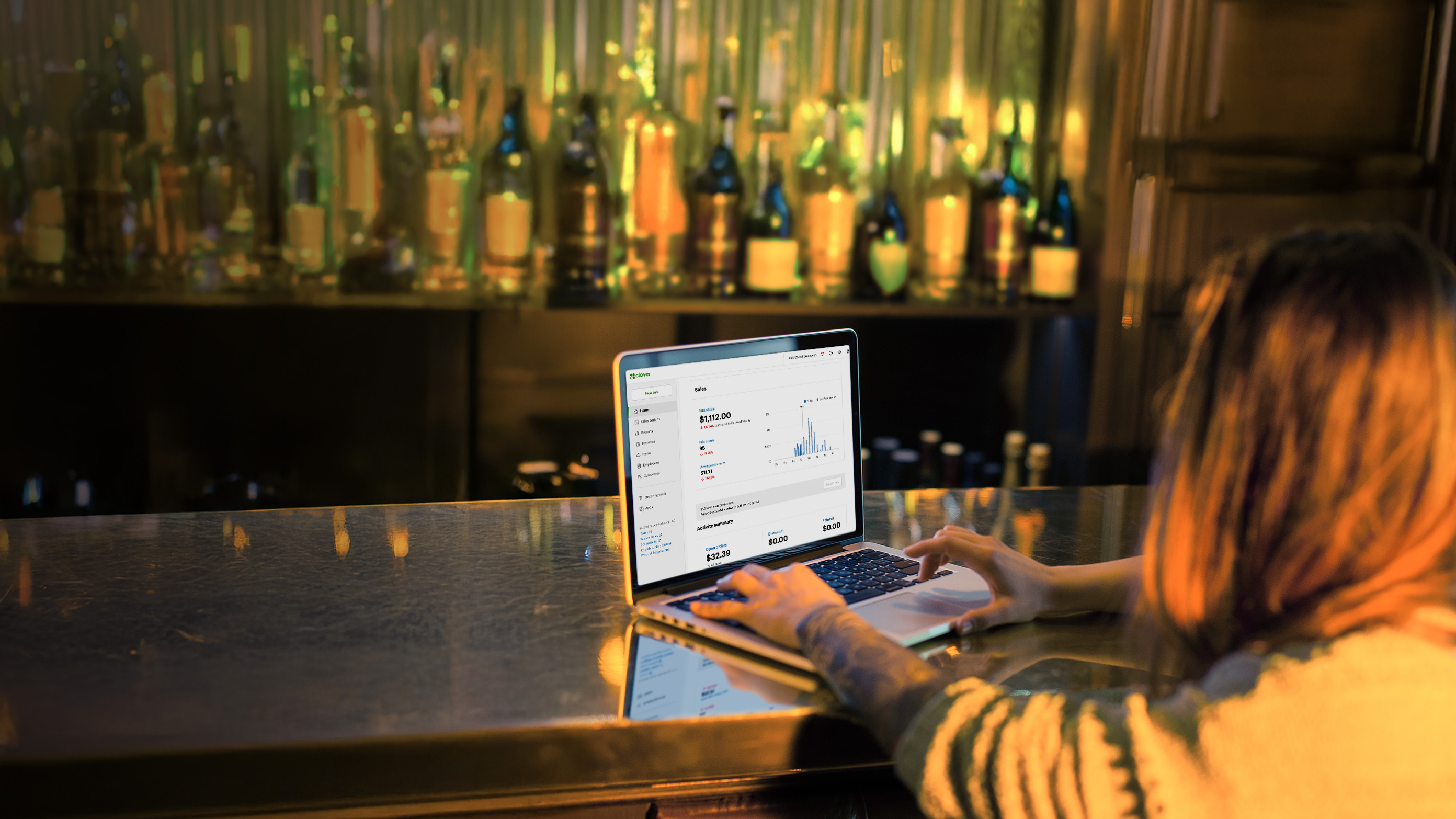 A man sitting at the bar working on laptop.
