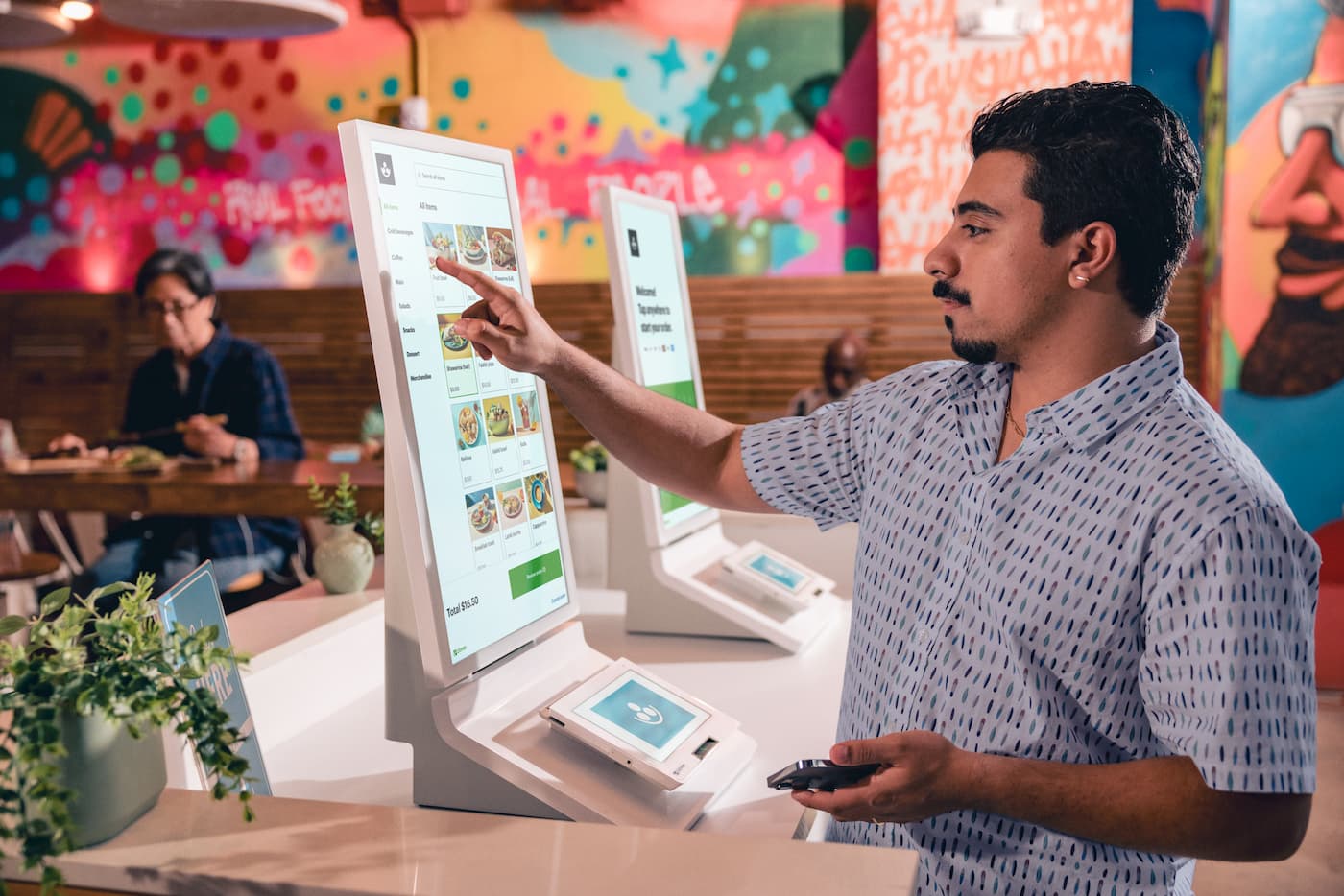 Man enters order into Clover Kiosk.