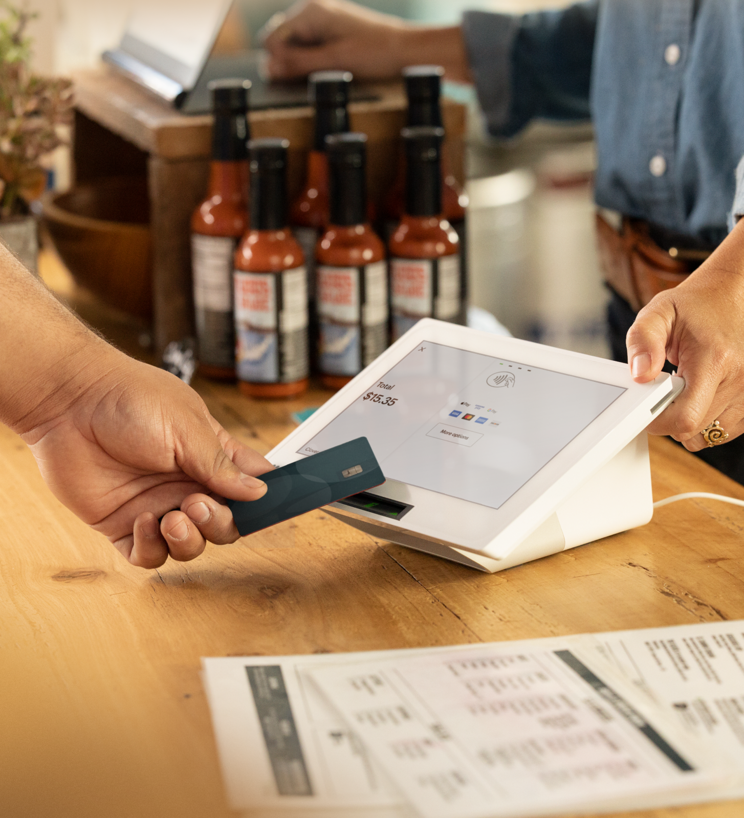 Customer making contactless payment via card on apple tap to pay device