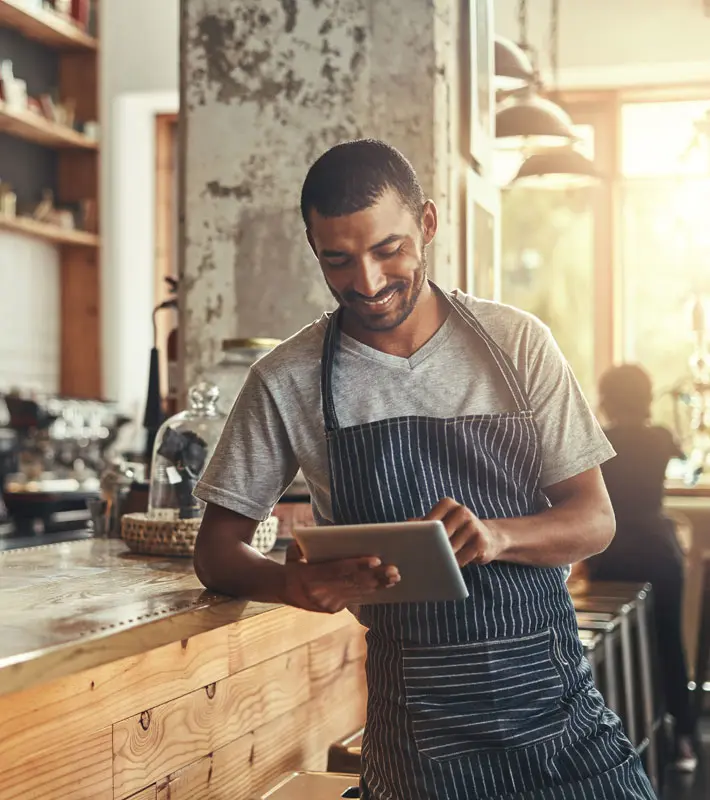 Owner of a coffee shop looking at a device