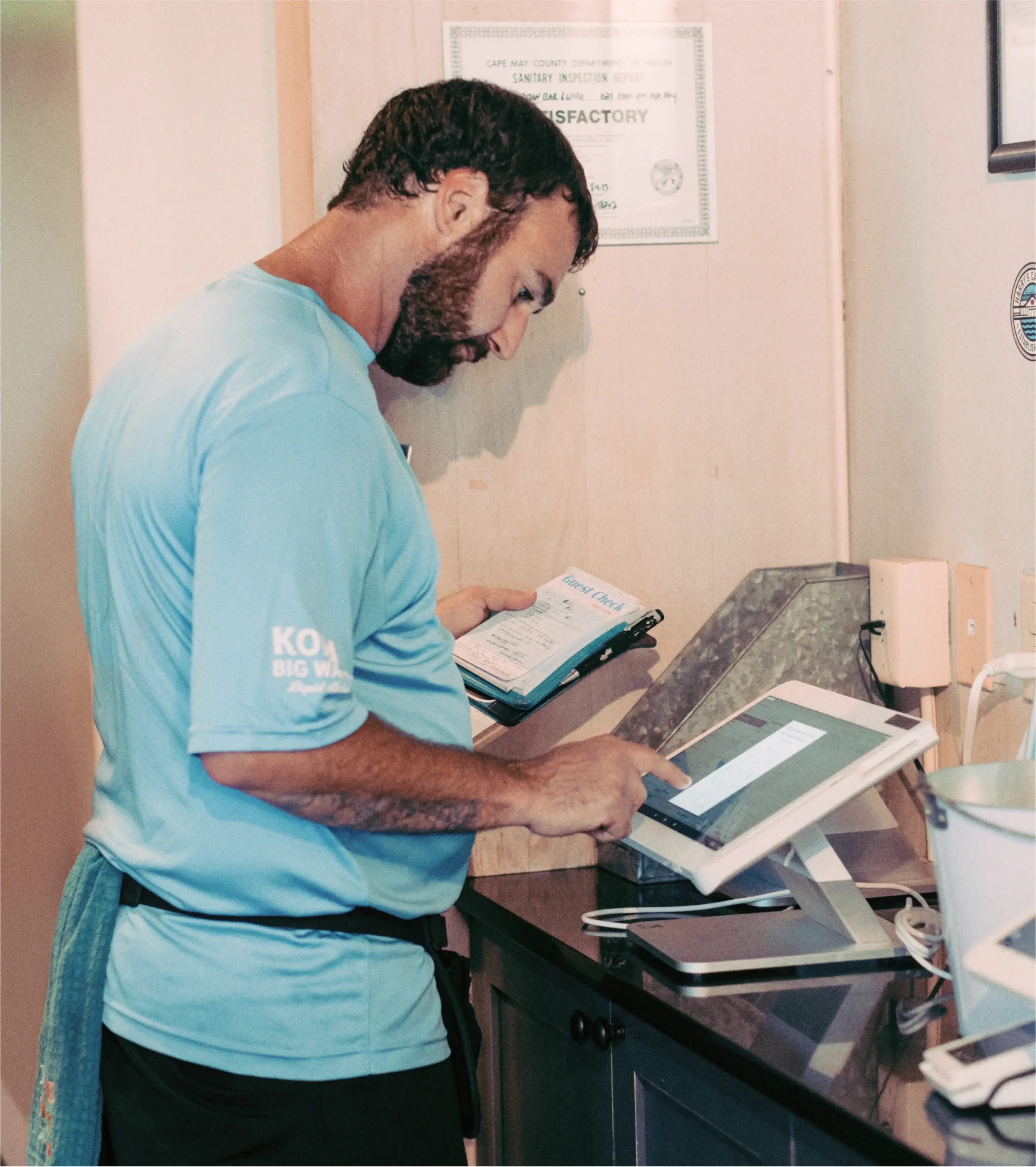 Restaurant server placing a customer order in back of house on a station solo