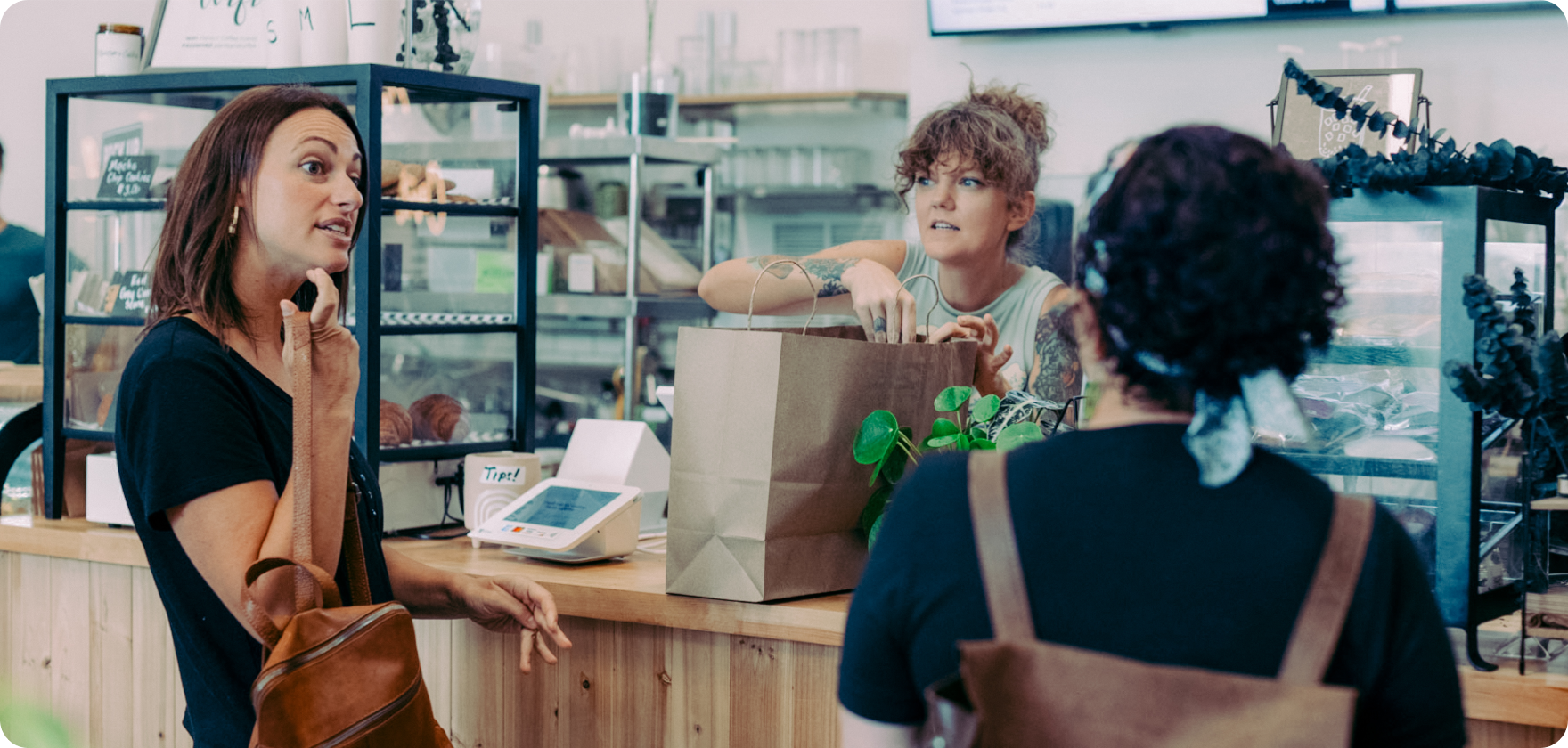 Plant shop associate helps customer check out