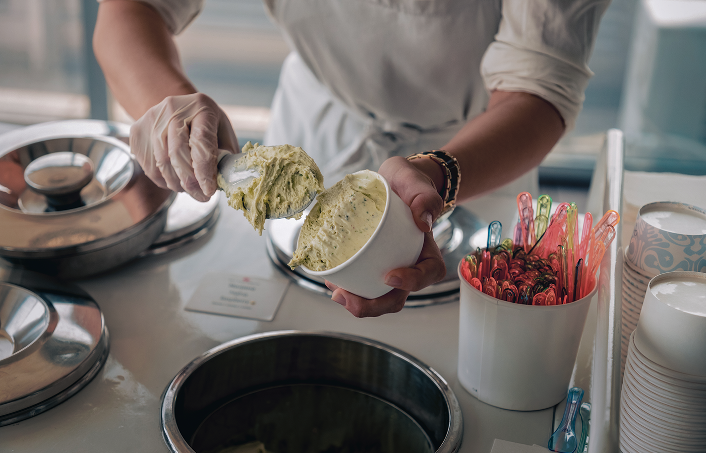 Store attendant scoops ice cream into a cup