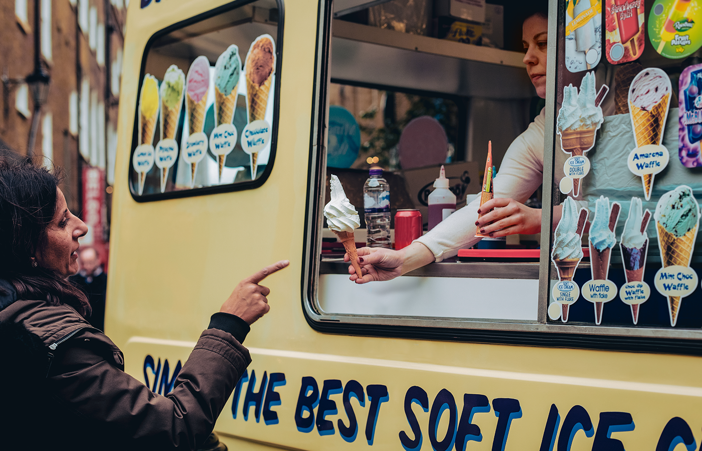 Woman purchases ice cream from an ice cream truck