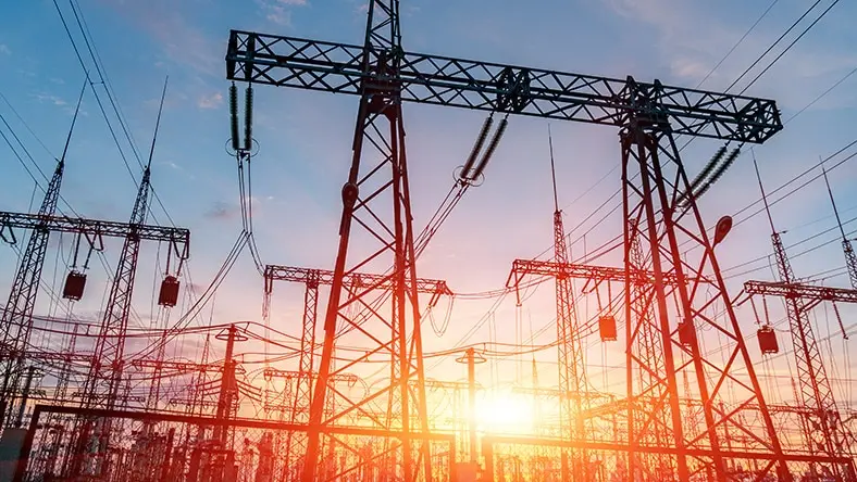 A photograph of an electrical substation shows scaffolding and transformers.