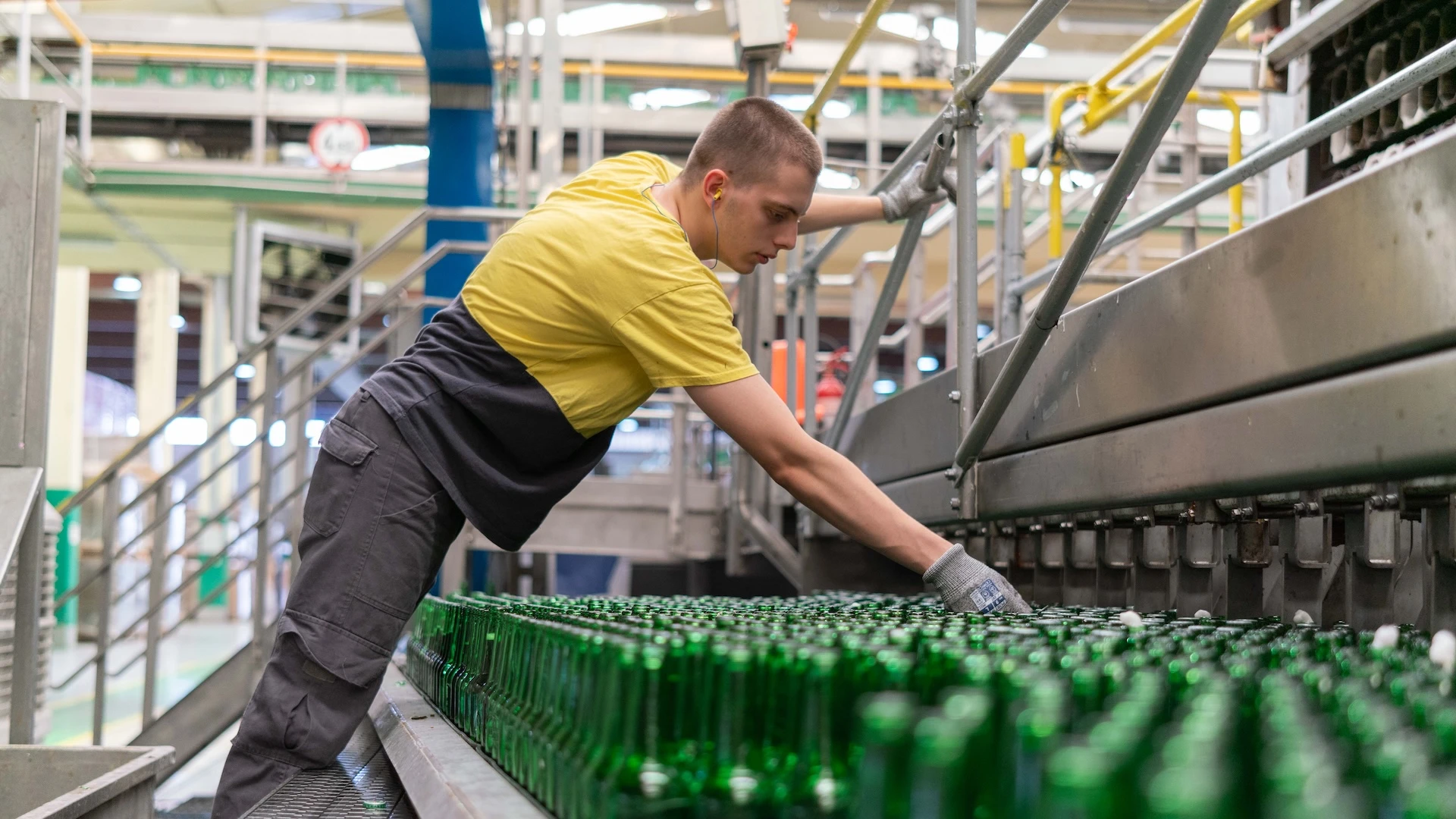 An individual checking bottles at a brewery