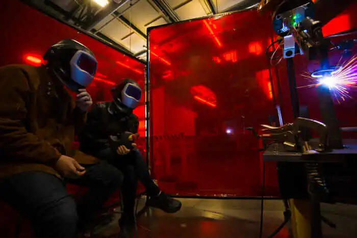 Factory workers wear helmets.