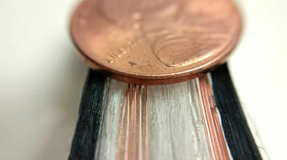 A multimaterial strand with copper