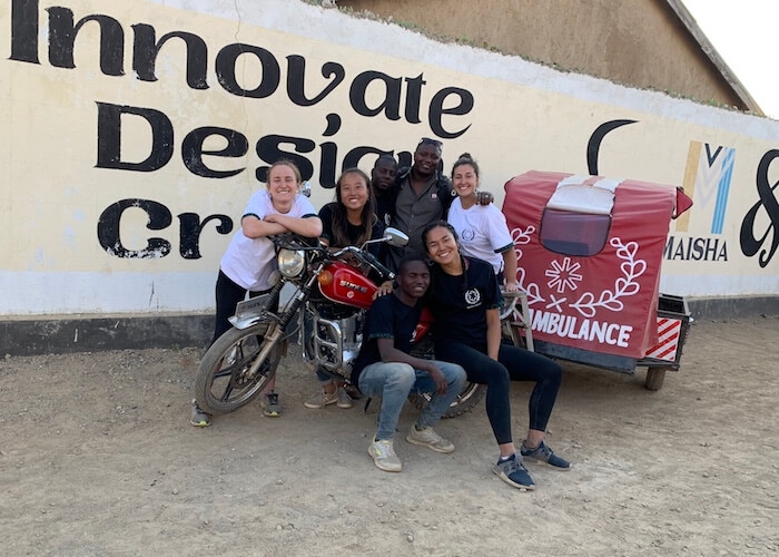 The Okoa Project team pose with an ambulance trailer in Mbeya, Tanzania.