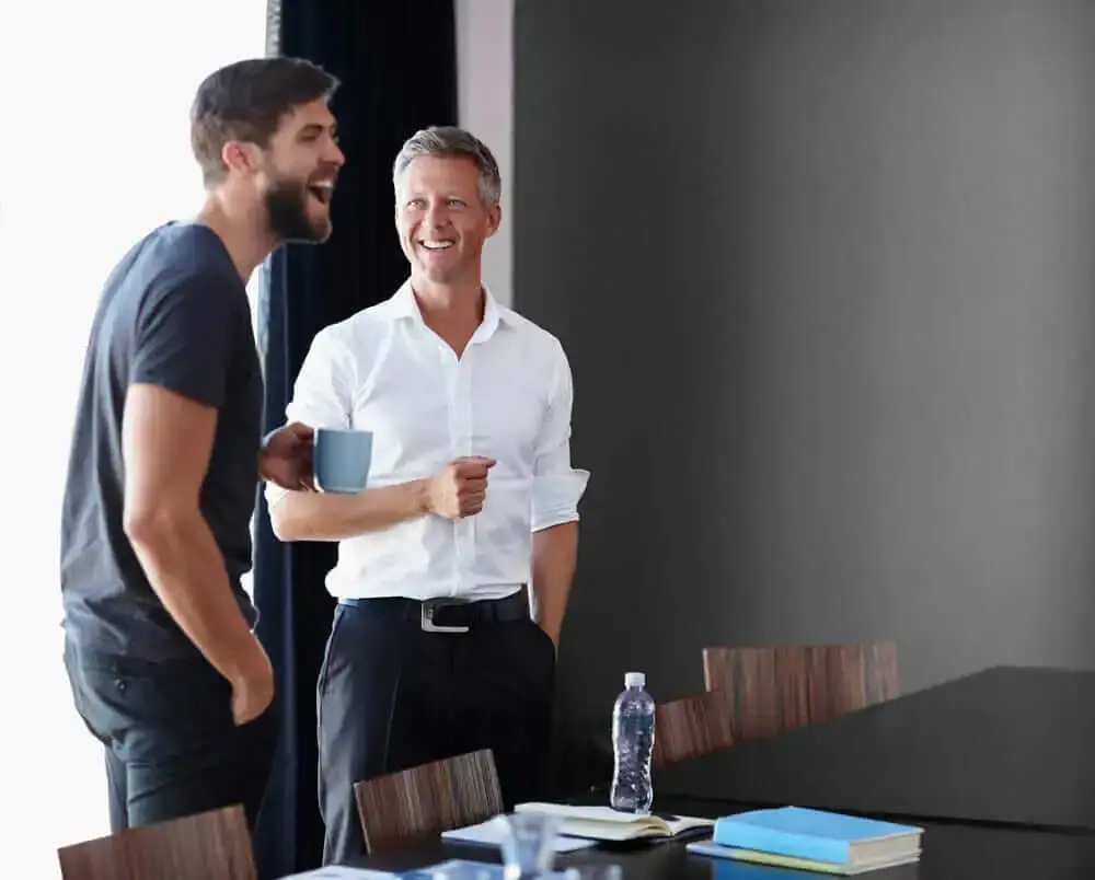 Two men laugh in an office setting