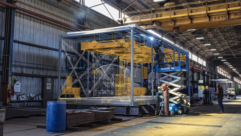 Prefab units under construction in a massive factory.