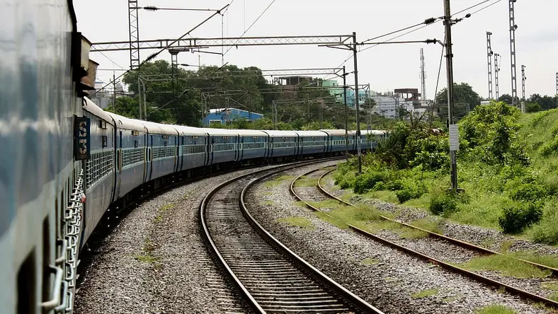 Train rounding a curve with overhead catenary
