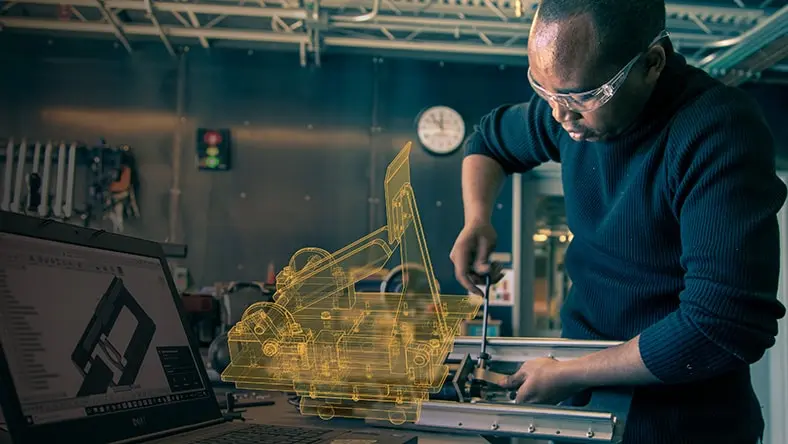Man working on physical product while consulting his Autodesk CAD software.