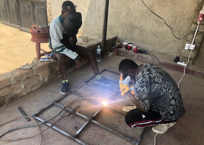 Local Tanzanian technicians weld a frame for the ambulance.