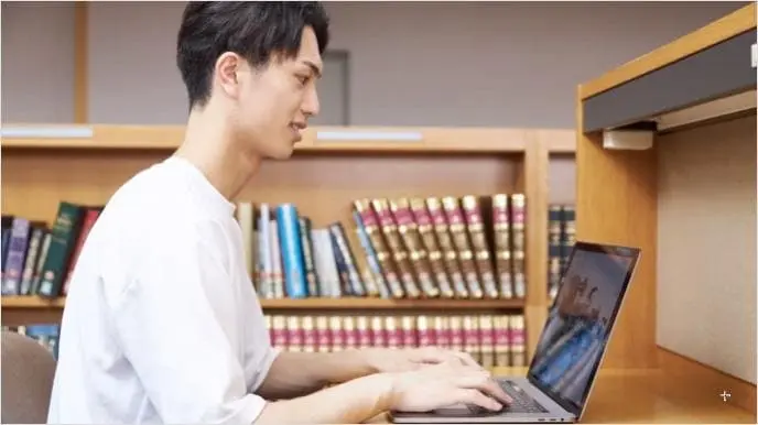 A man sitting at a desk using a computer.