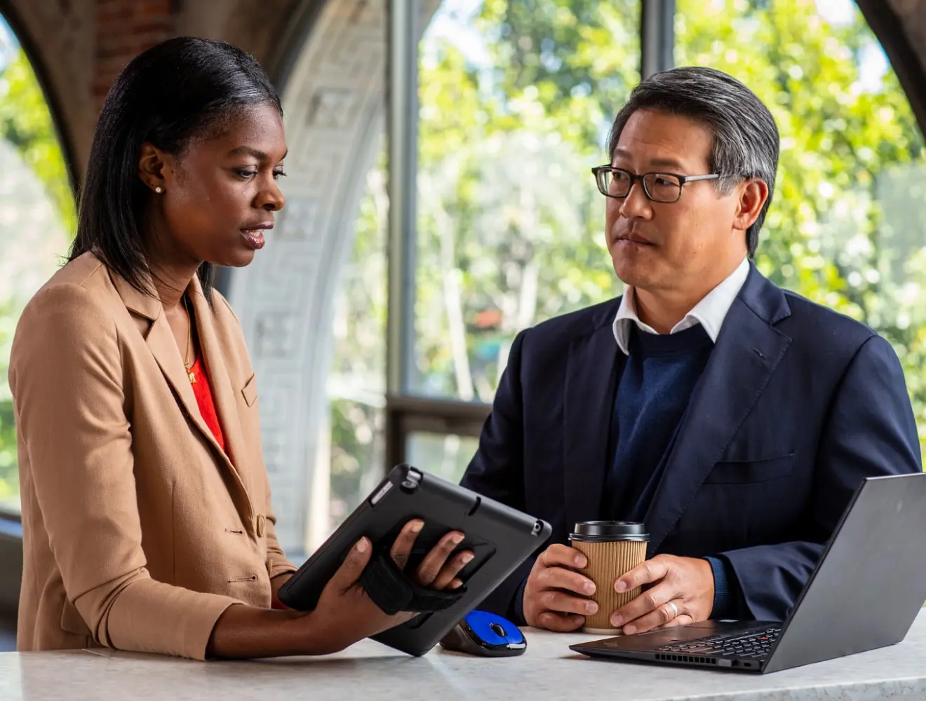 Employees collaborating on a tablet and laptop