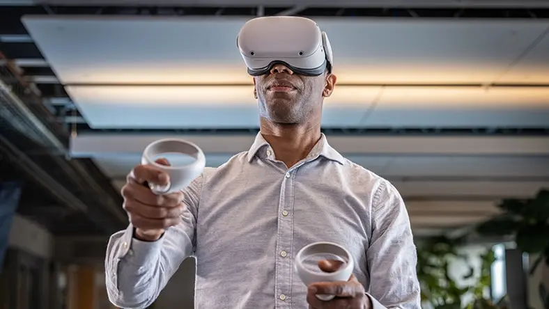 Person wearing Meta Quest glasses and holding controllers