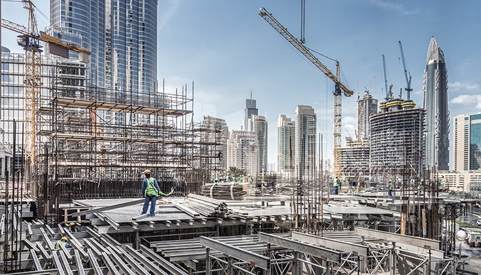 A busy construction site with a city skyline in the background