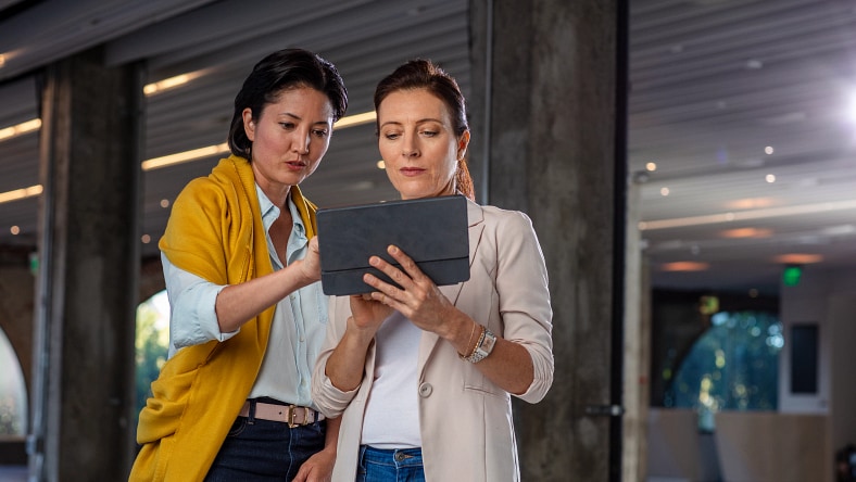 Two professionals collaborating on a tablet