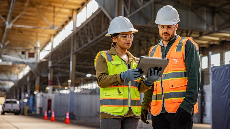 Workers viewing a digital tablet at a construction site