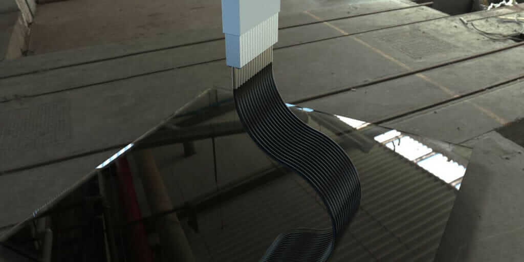 A composite part emerges from Continuous Composites' 3D printer.