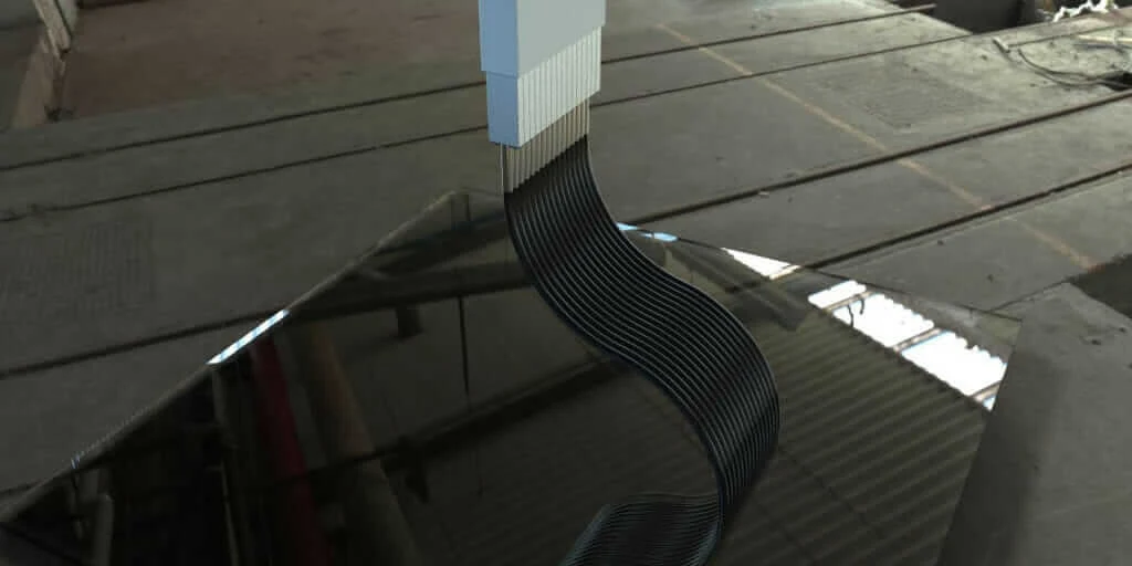 A composite part emerges from Continuous Composites' 3D printer.