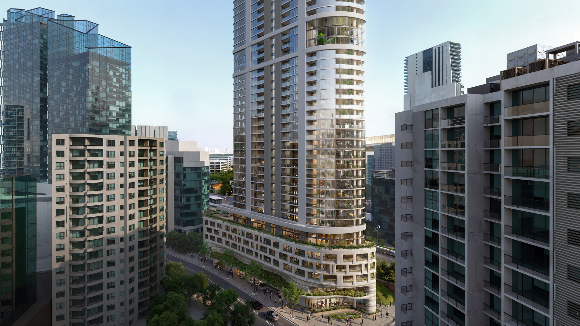 Modern high-rise buildings with glass facades, balconies, and greenery at the base in an urban setting.