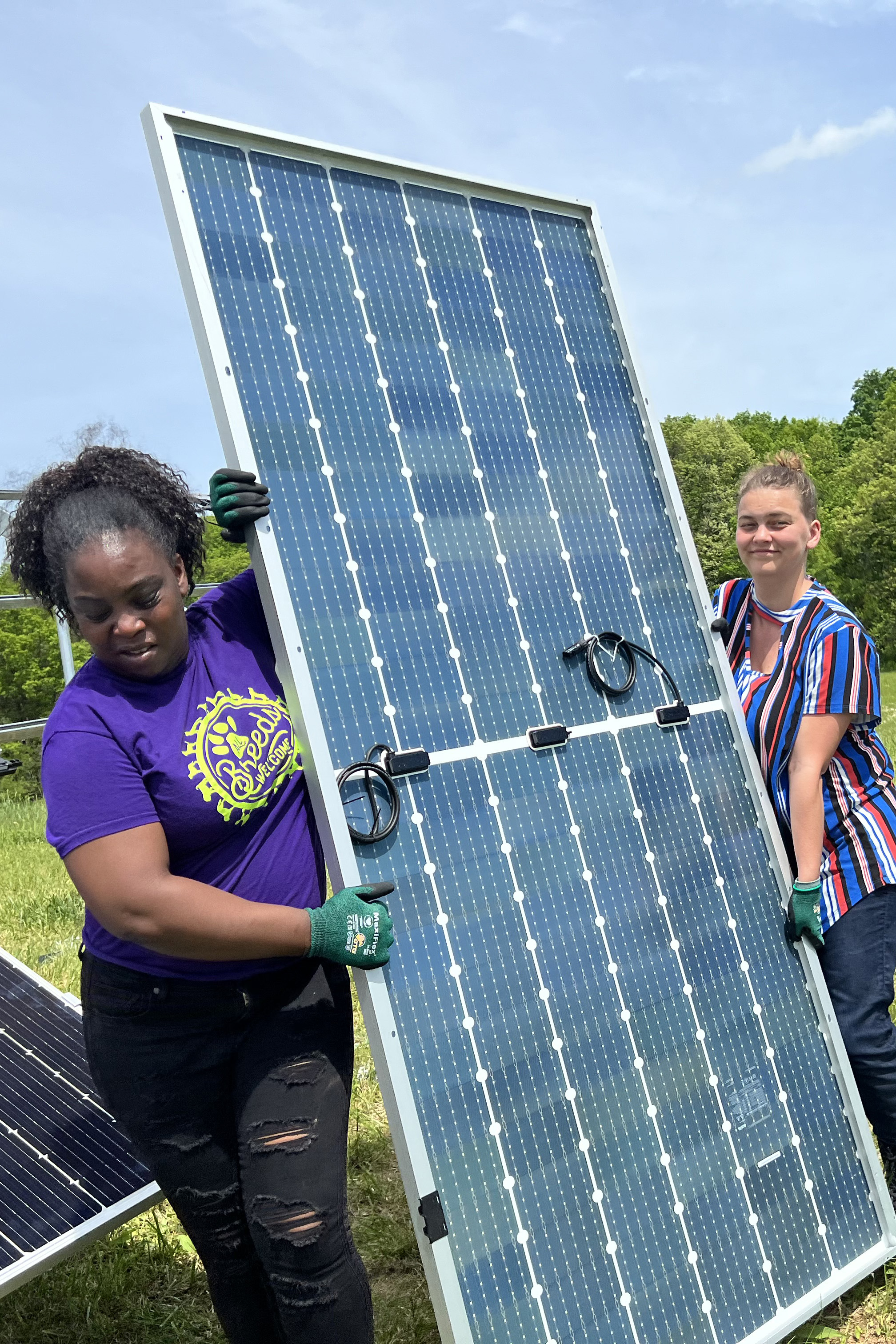 People carrying a vertical solar panel