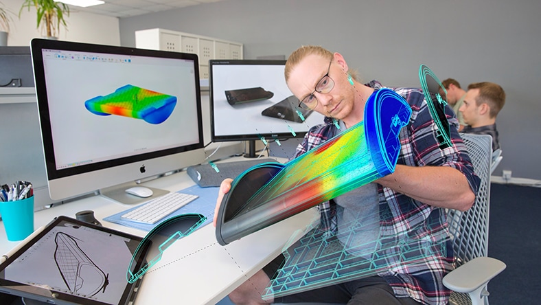 Engineer working at desk, looking at component being designed with Autodesk Fusion