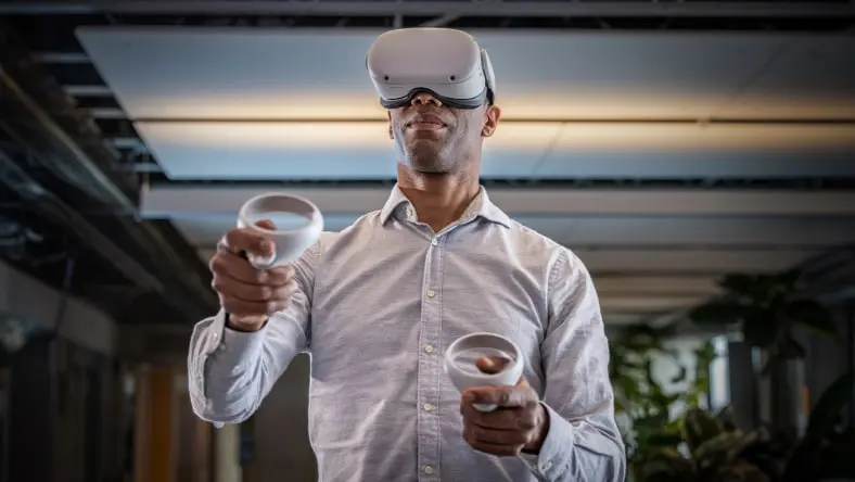 Person wearing Meta Quest glasses and holding controllers