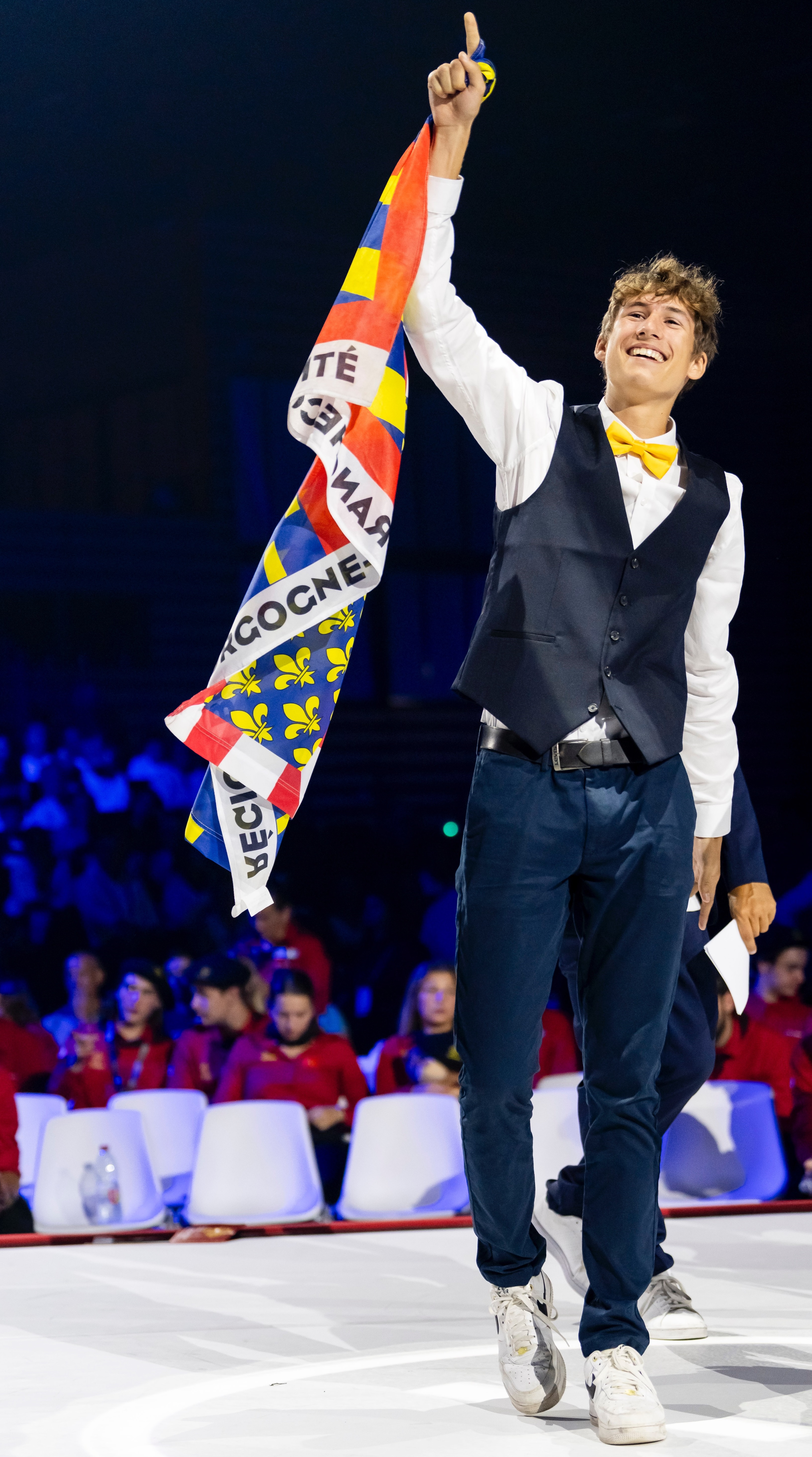 Basile Menassol walking on stage with flag