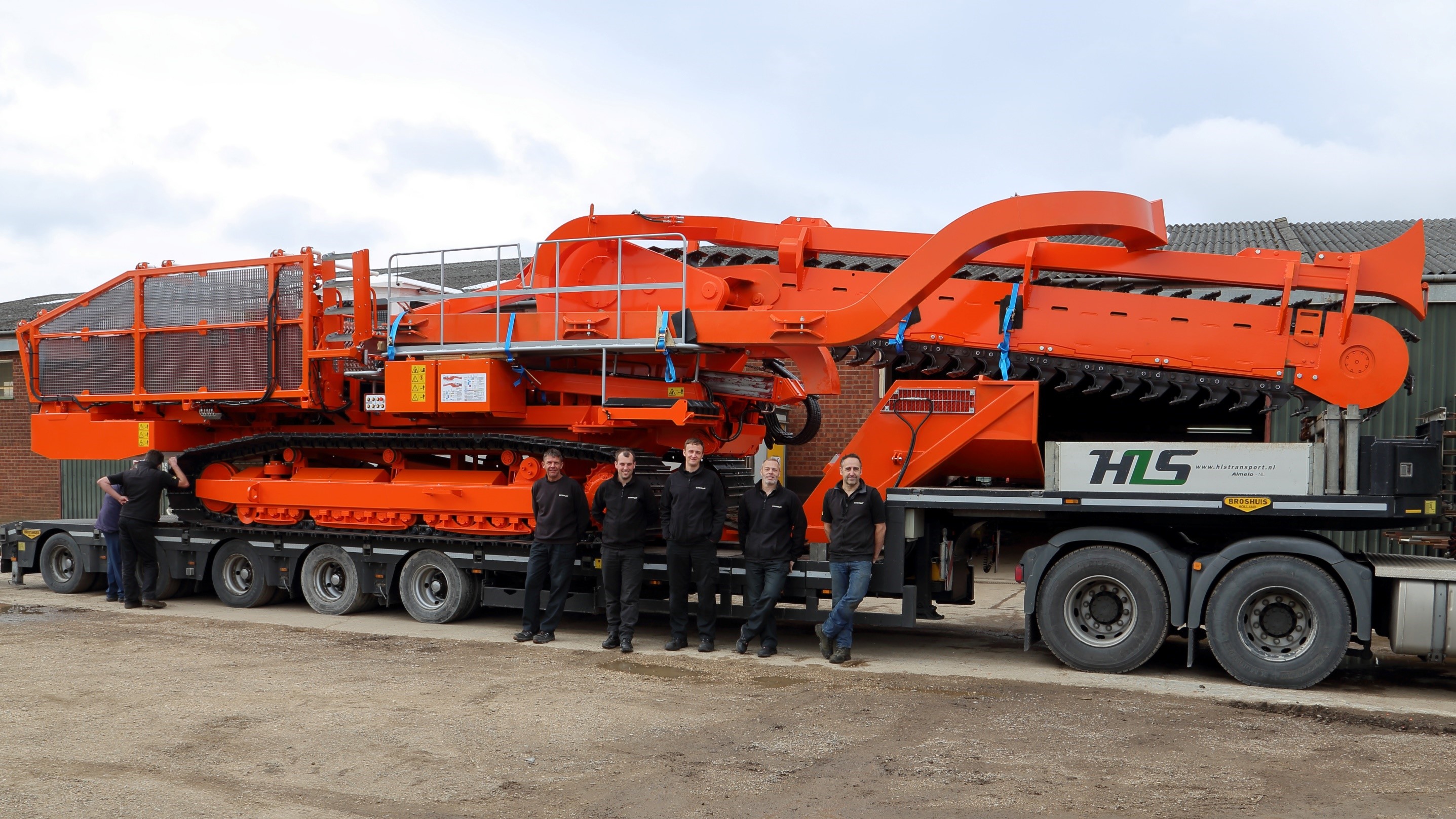 The Mastenbroek engineering team pose in front of a custom, self-propelled trenching machine.