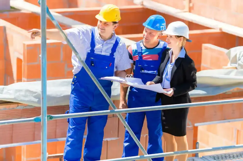 Three people on a construction site