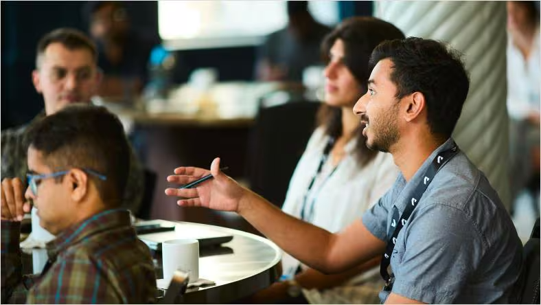 Conference attendees seated at tables during a PLM session.