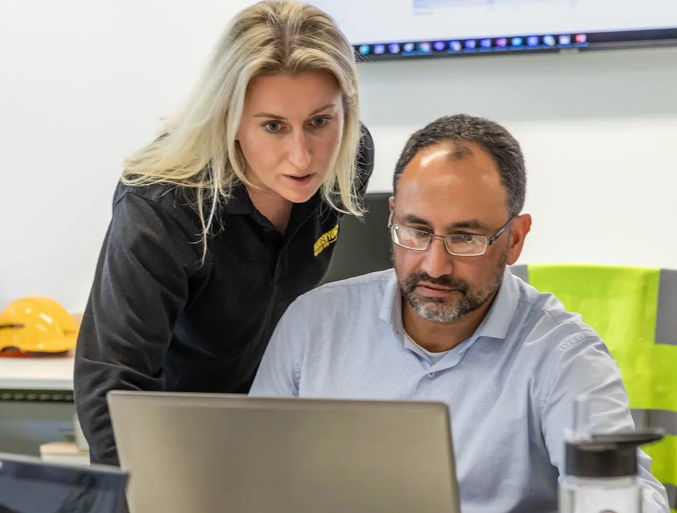 Two utility workers looking over a computer
