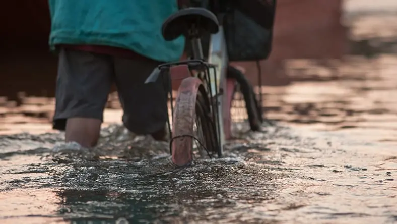 Guy with a bike in a flood