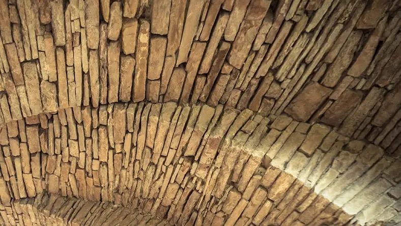 A photo of a curved brick surface shows weathered details.