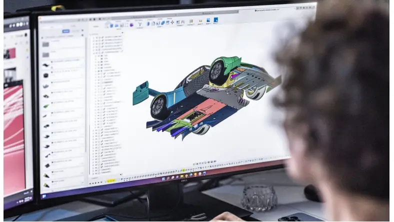 Man creating 3d model of car using Fusion 360 on computer.