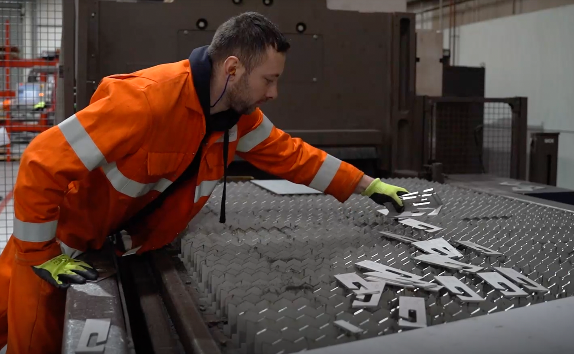 Worker picking up parts from a tray