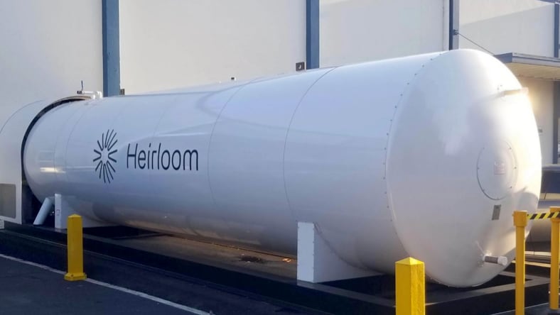 Front-side view of large, white tank with Heirloom logo on the side. Sunlight shining in from the right side of the photo.