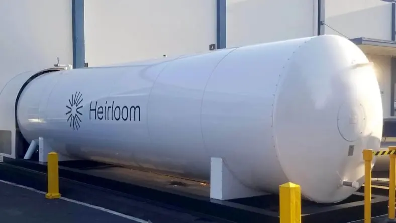 Front-side view of large, white tank with Heirloom logo on the side. Sunlight shining in from the right side of the photo.