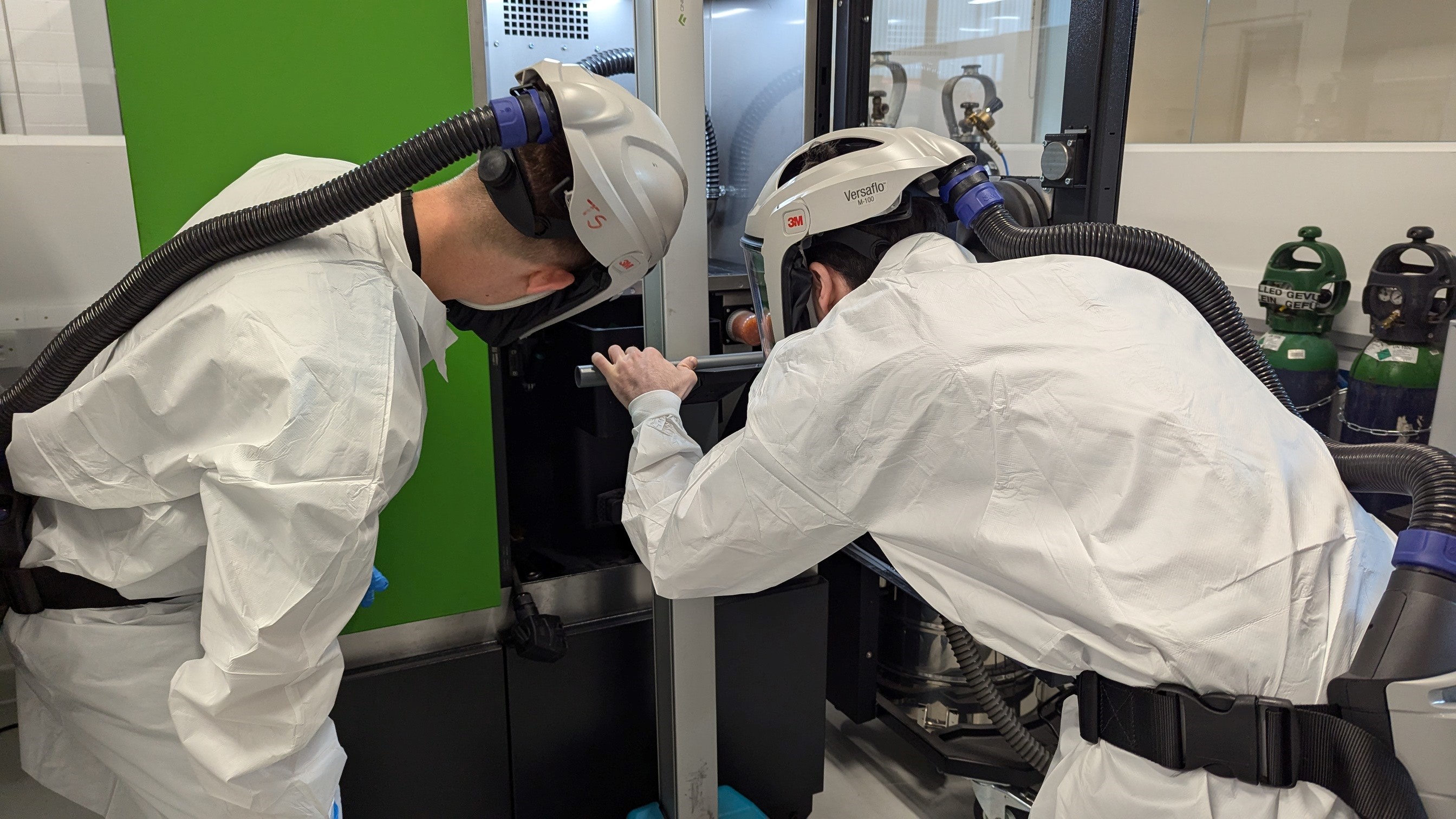Two men inspecting a part from a 3D printer
