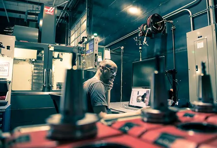 A worker supervises autonomous machinery.