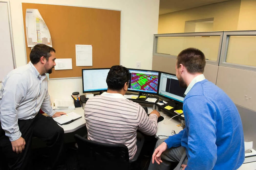 Three members of Cannistraro’s VDC Group (Virtual Design & Construction) working at a computer