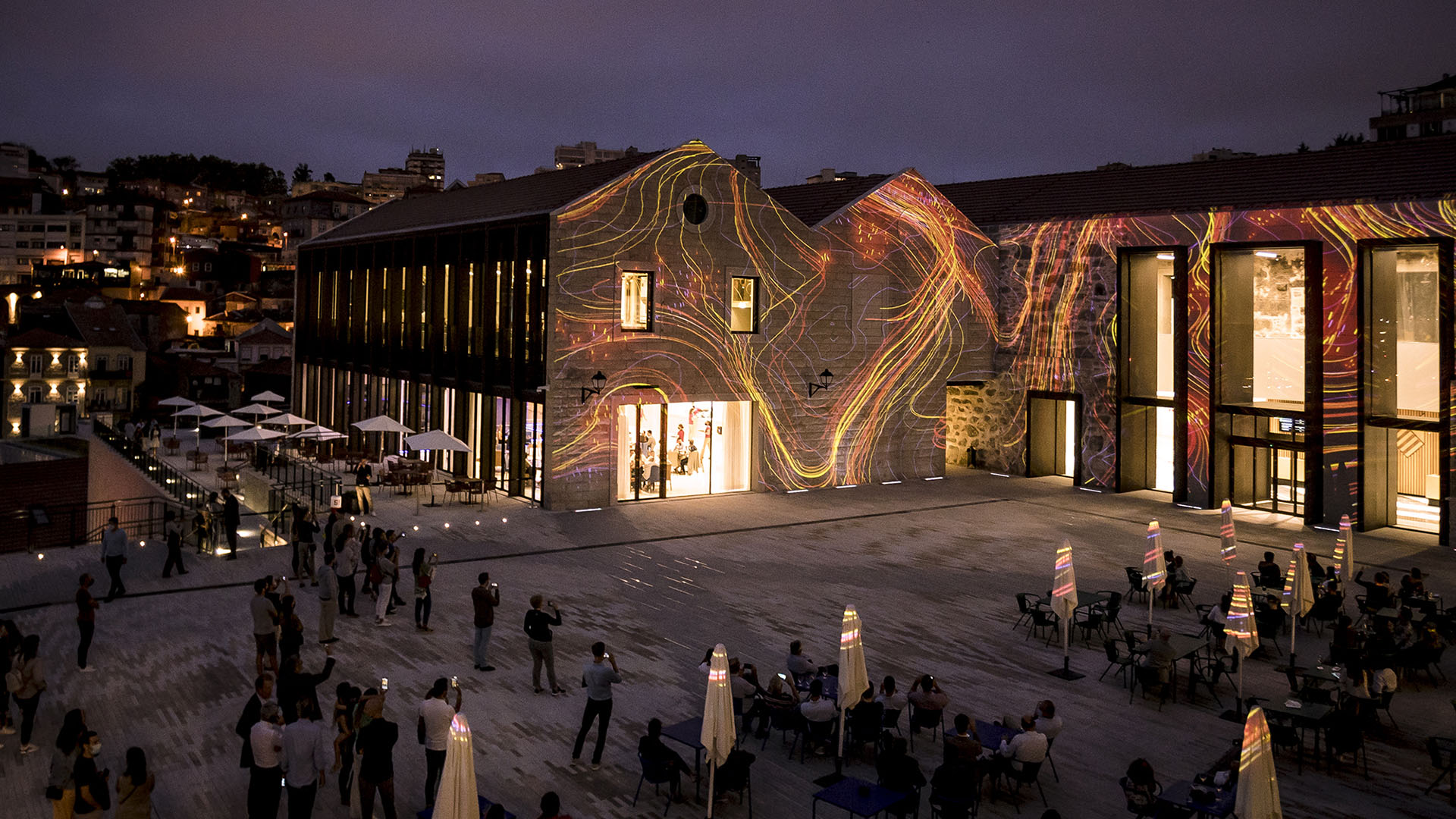 A view of the World of Wine at night shows a dramatic lightshow on its facade.