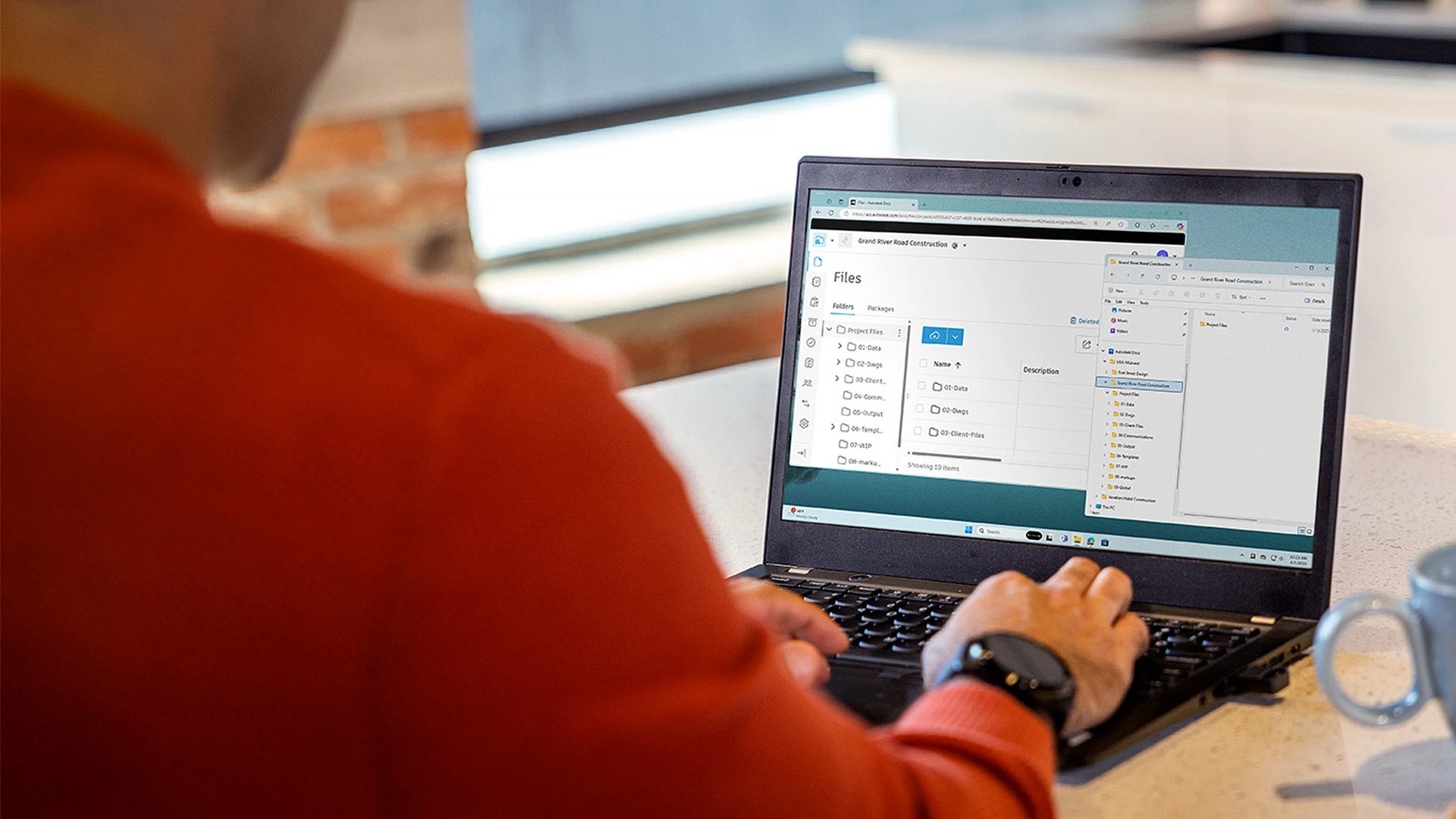 Person using a laptop displaying a project files interface.